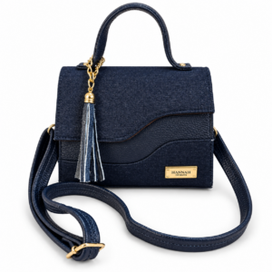 Vita navy denim and leather-blend bag with curved top handle, asymmetric flap and decorative tassel.